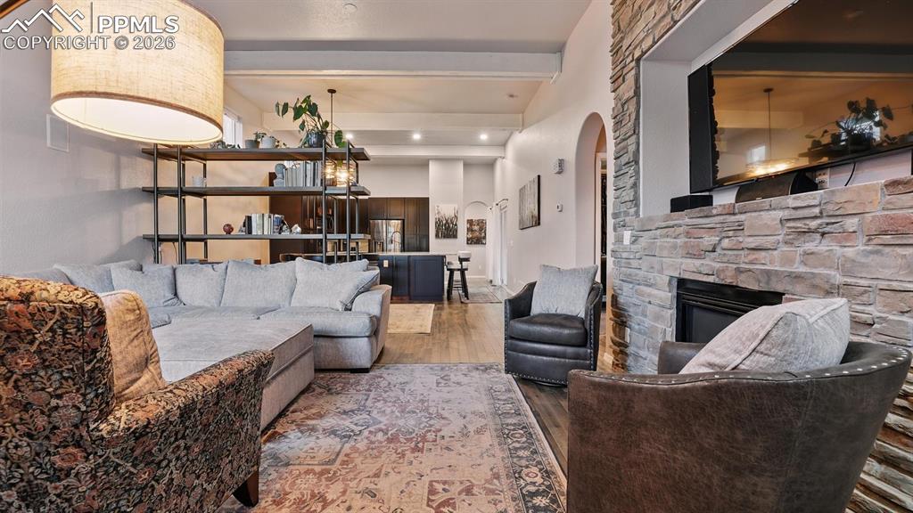 Image 9 of 50: The inviting Living Rm features a gas log fireplace with stacked stone surr