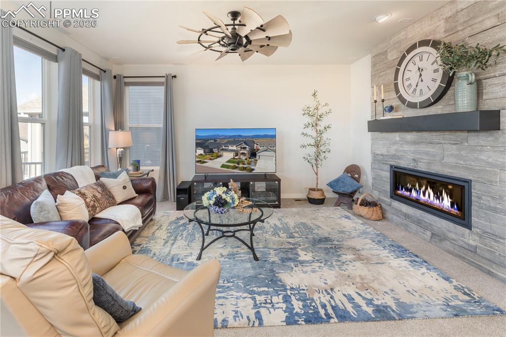 Image 13 of 50: Upgraded floor-to-ceiling tile fireplace and ceiling fan.