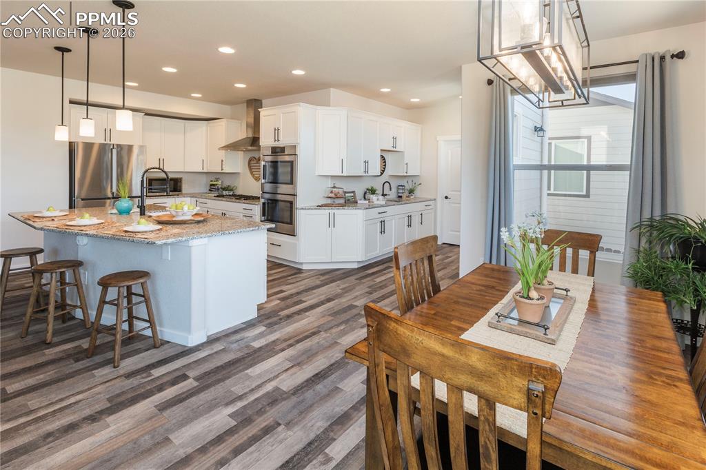 Image 16 of 50: Kitchen with granite countertops, stainless steel appliances, white cabinet