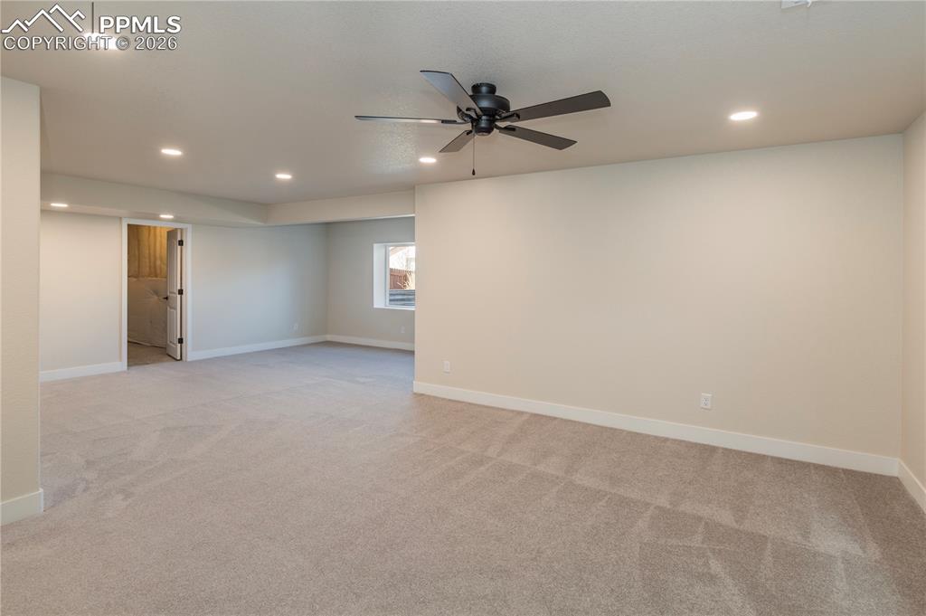 Image 45 of 50: Newly finished rec room area feels bright and spacious. Unfinished storage