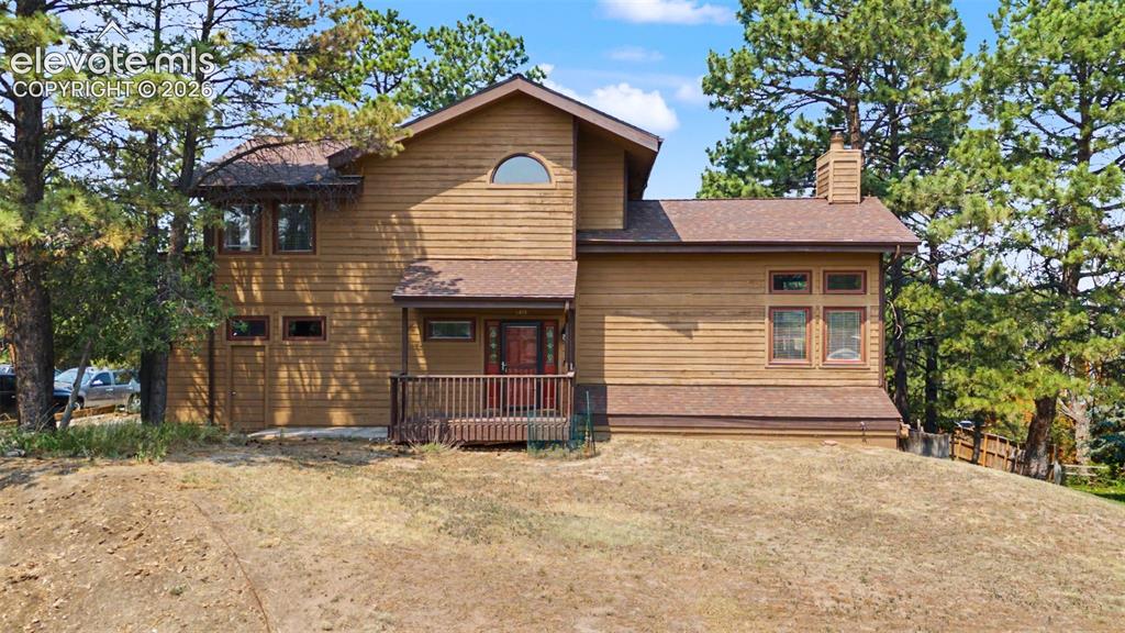 Image 1 of 44: Wood-sided residence featuring a covered front porch with railings, multipl