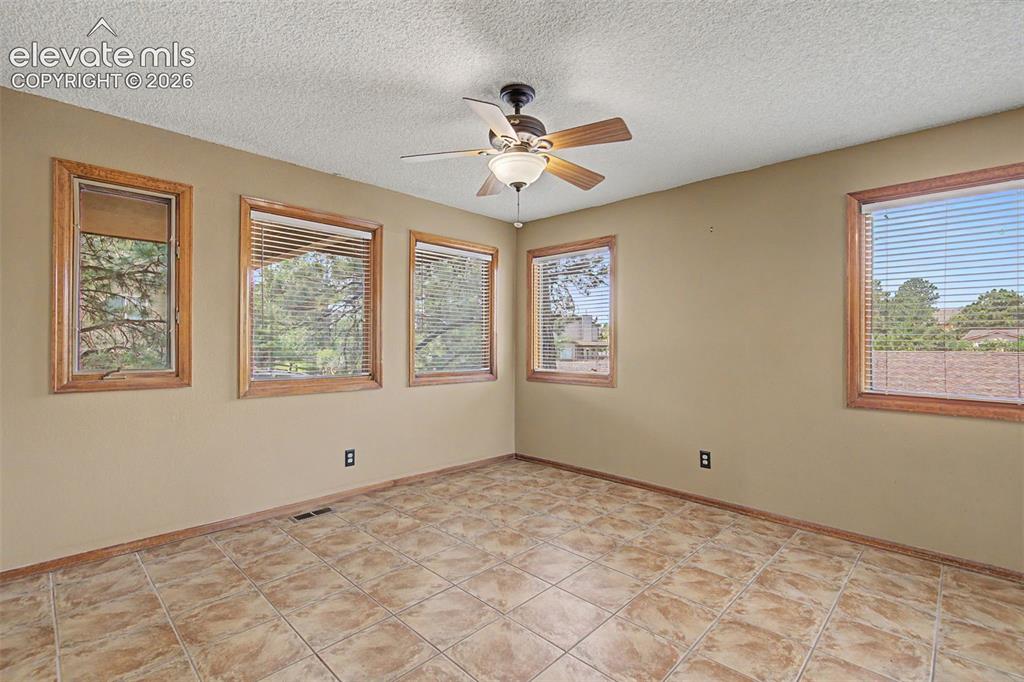 Image 11 of 44: Spacious room featuring five windows with wood trim, ceramic tile flooring,