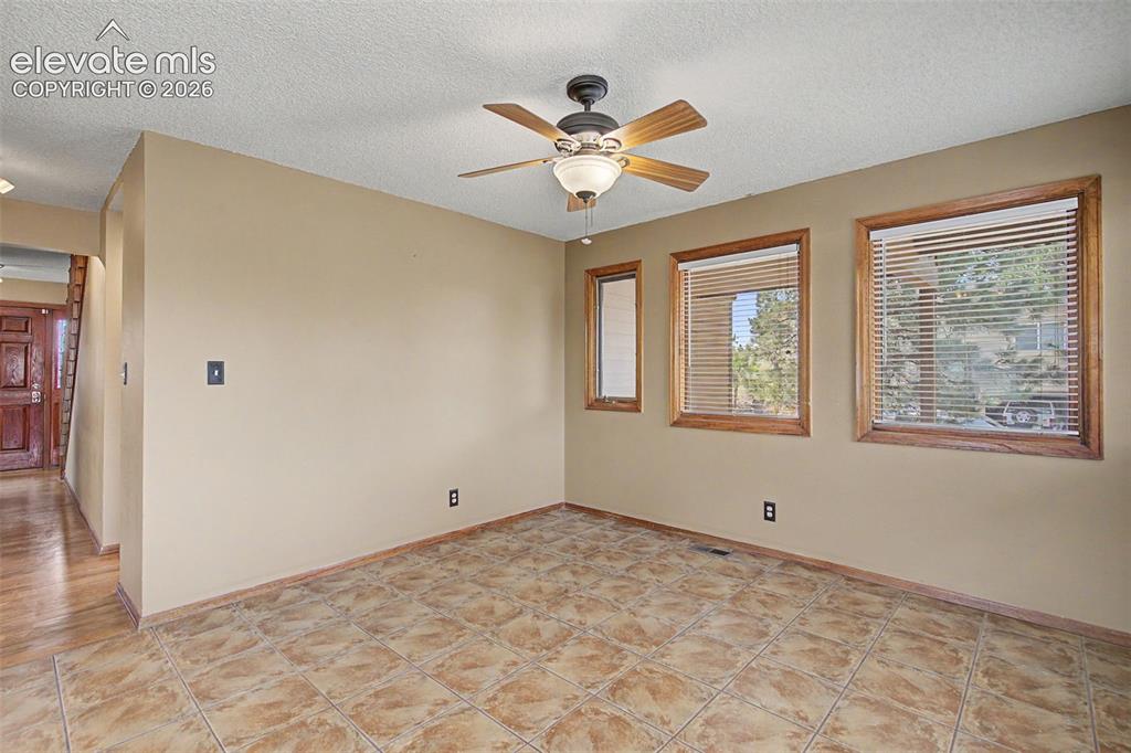 Image 14 of 44: Tiled flooring throughout this space, featuring multiple windows with wood