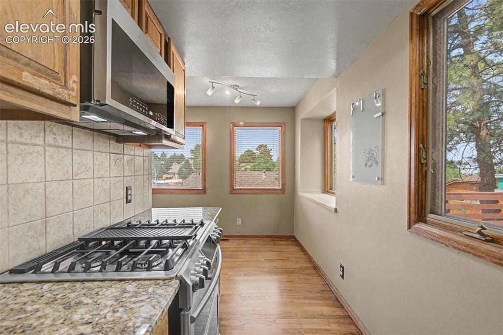 Image 19 of 44: Kitchen featuring a stainless steel gas range with griddle, granite-look co