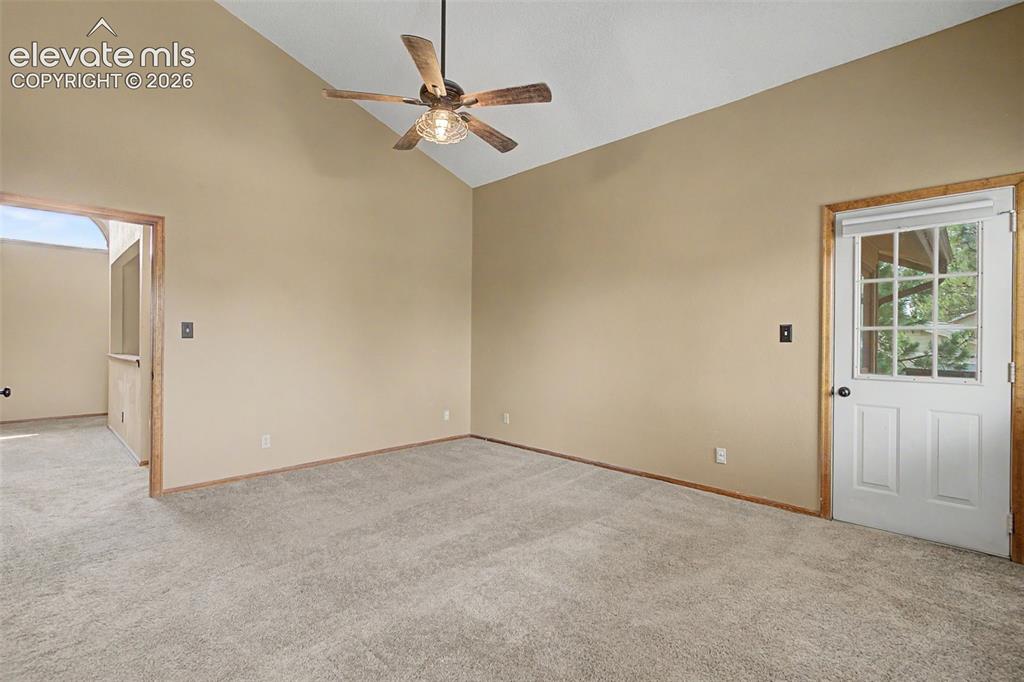 Image 28 of 44: Spacious room featuring vaulted ceilings, light-colored carpeting, and neut