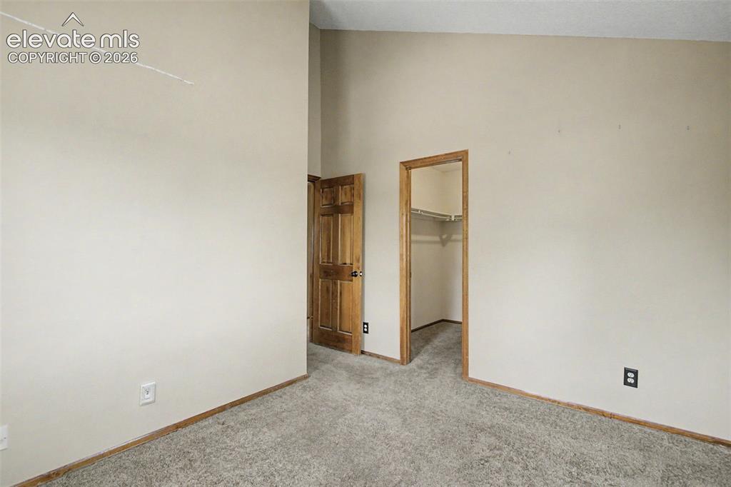 Image 33 of 44: Carpeted room featuring a natural wood-finish door, a natural wood-finish d