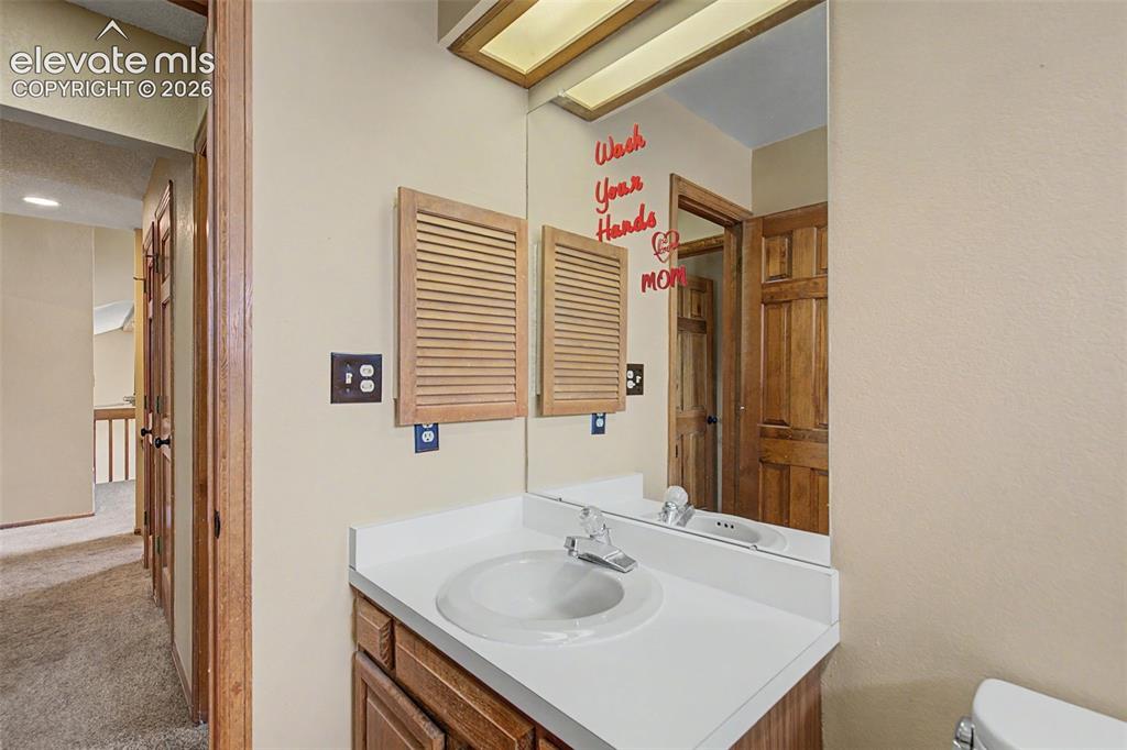 Image 35 of 44: Bathroom vanity featuring a white countertop, oval sink, and chrome faucet