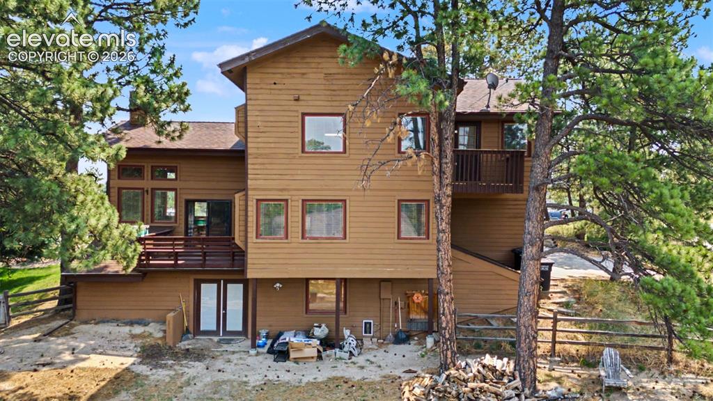 Image 4 of 44: Multi-level exterior with natural wood siding and a multi-paned window desi