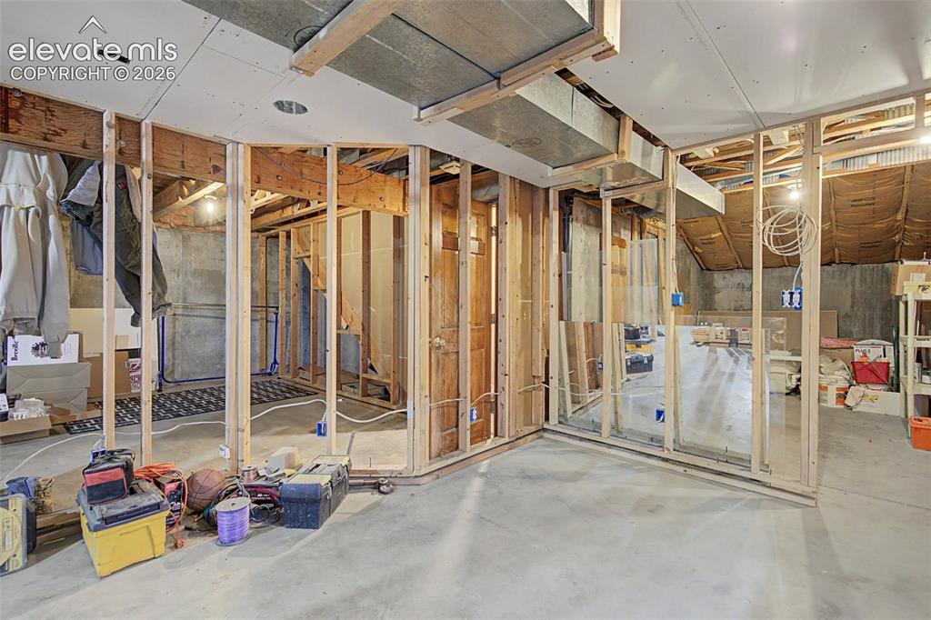 Image 41 of 44: Unfinished lower level with wood frame construction, concrete flooring, exp