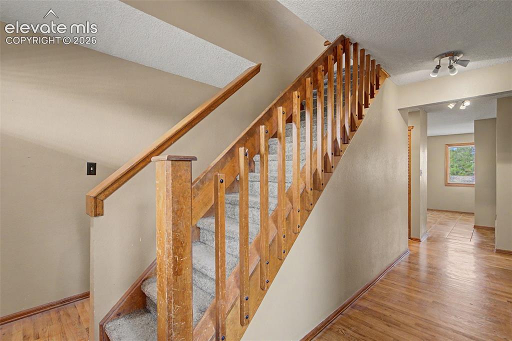 Image 9 of 44: Carpeted staircase with wooden banister and spindles