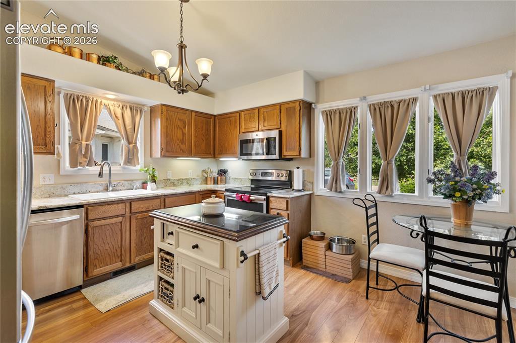 Image 24 of 43: Spacious eat-in kitchen features solid granite countertops and stainless st