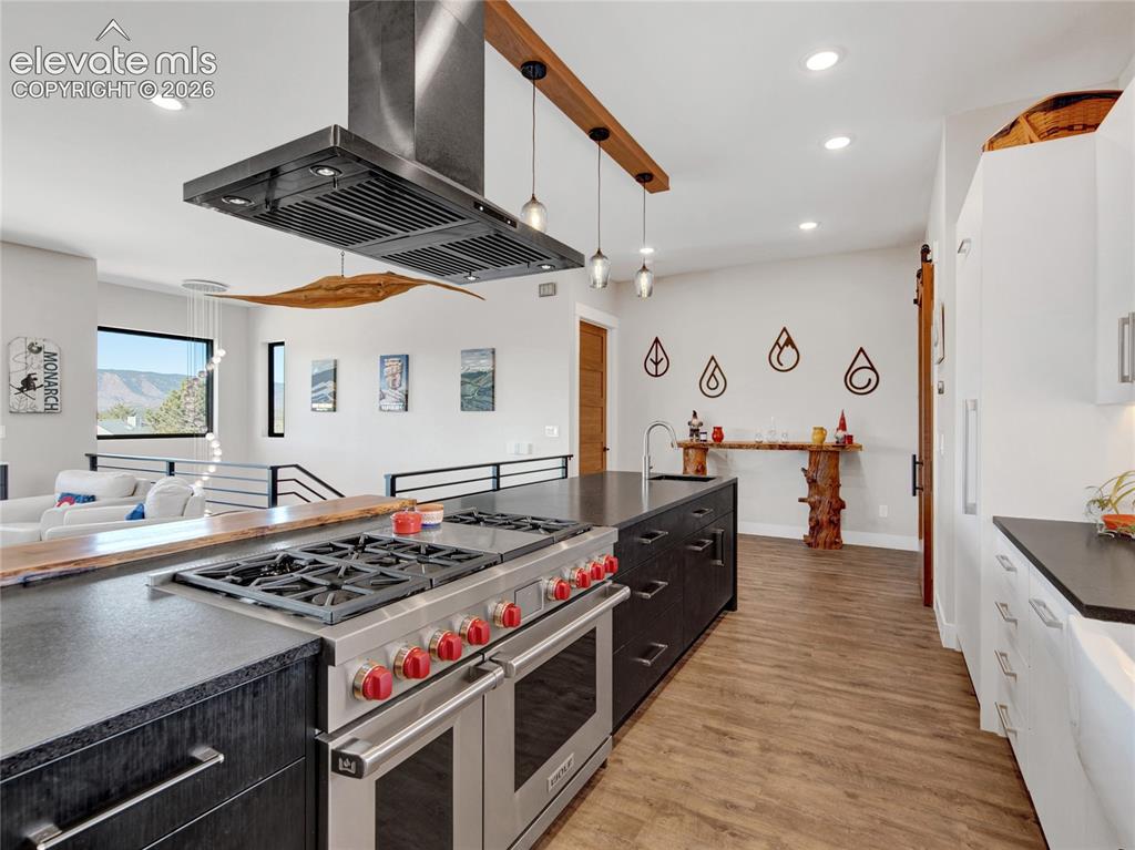 Image 14 of 49: Gourmet kitchen featuring a professional-grade range, stainless steel vent