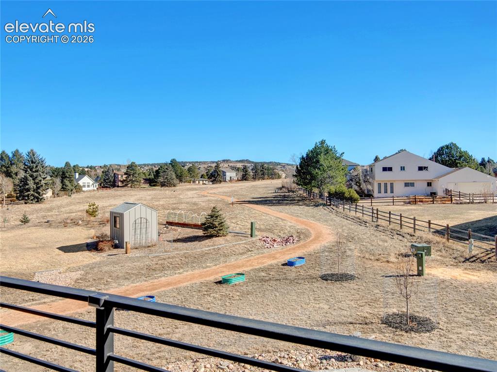 Image 19 of 49: Expansive property featuring a winding dirt path, a small shed, and a wood