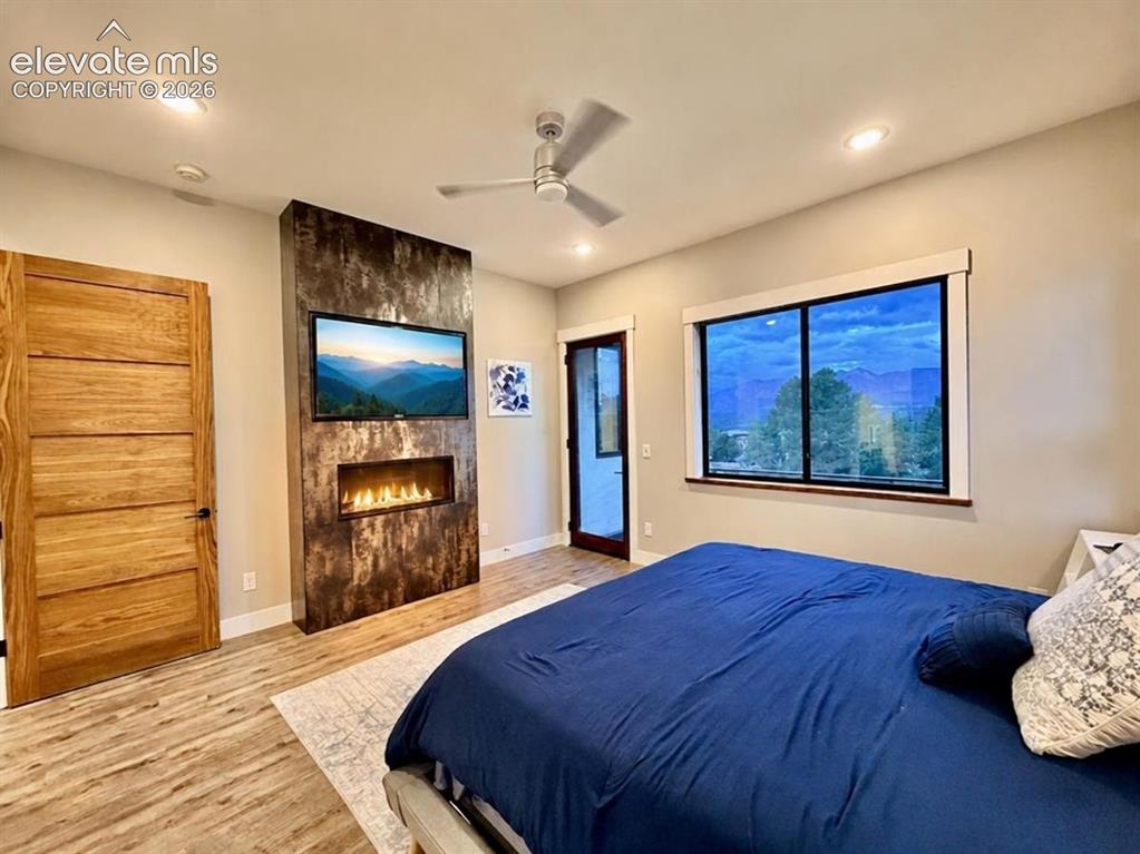 Image 21 of 49: Wood-finish flooring, accent wall with linear fireplace, recessed lighting,