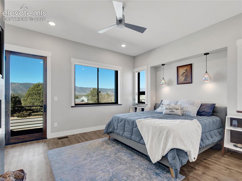 Image 22 of 49: Primary bedroom with a modern ceiling fan and gas fireplace.