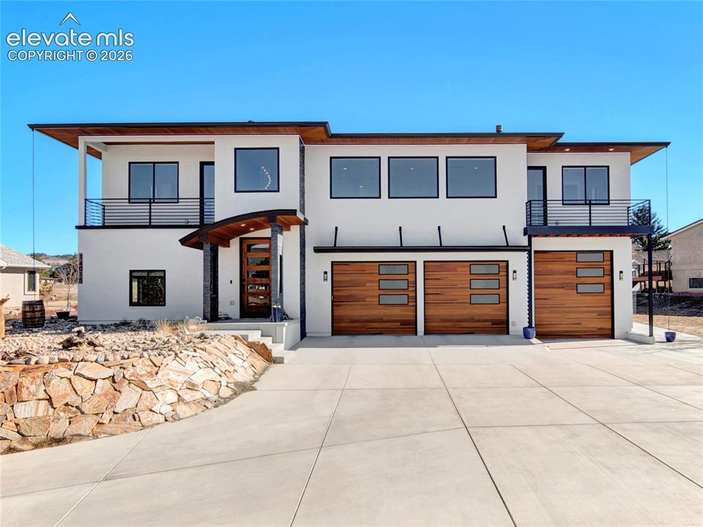 Image 3 of 49: Modern architectural exterior with concrete driveway