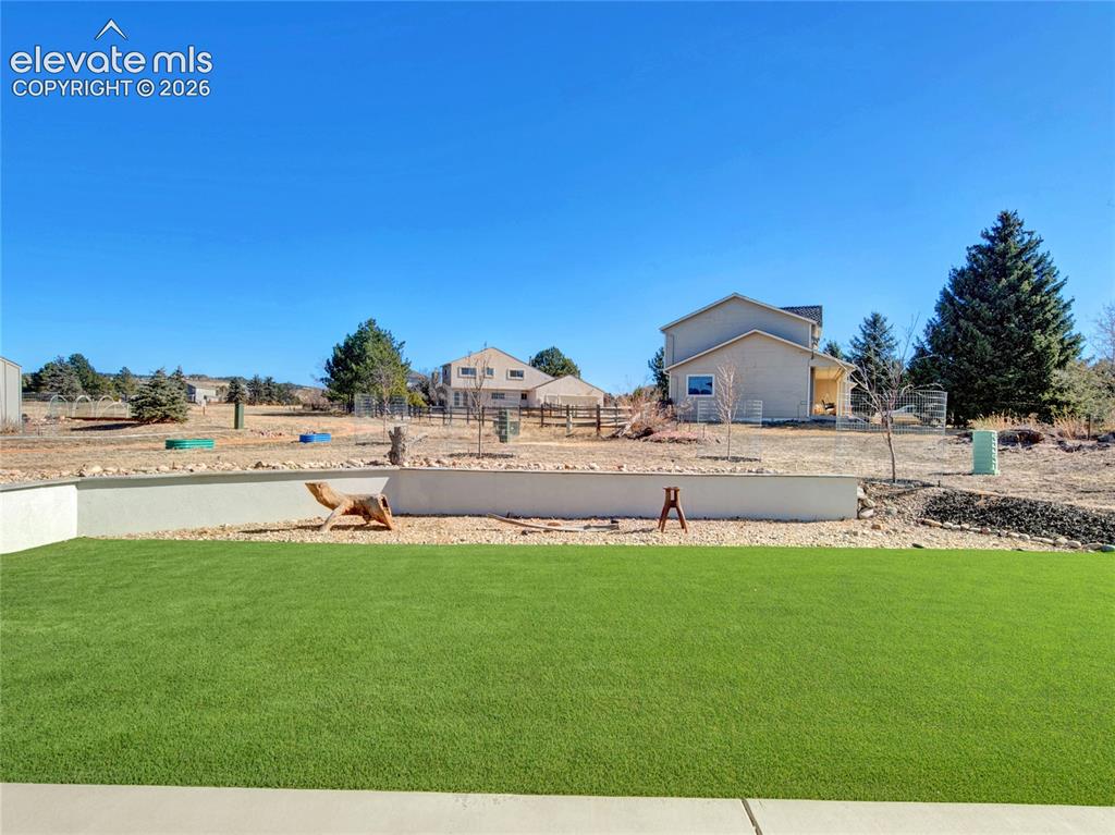 Image 35 of 49: Expansive artificial turf lawn with a concrete patio