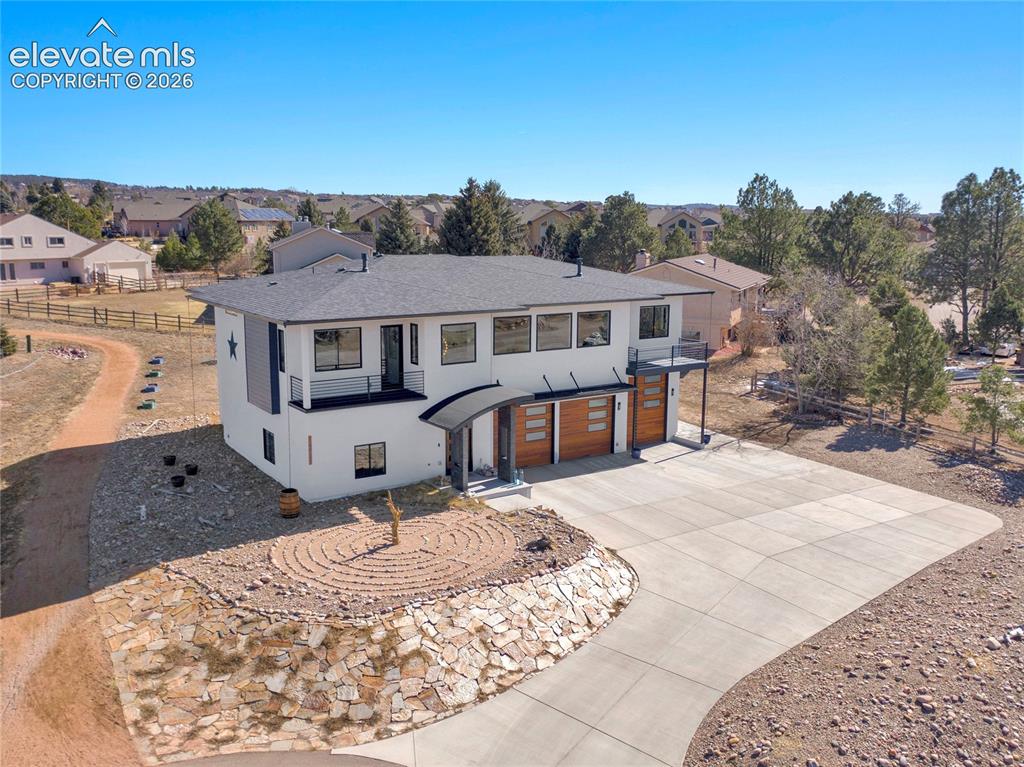 Image 40 of 49: Contemporary residence featuring a white stucco facade, black trim, and mul