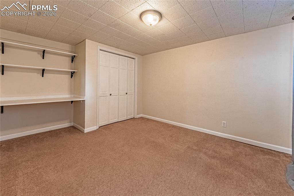 Image 36 of 49: 5th bedroom with built in shelves
