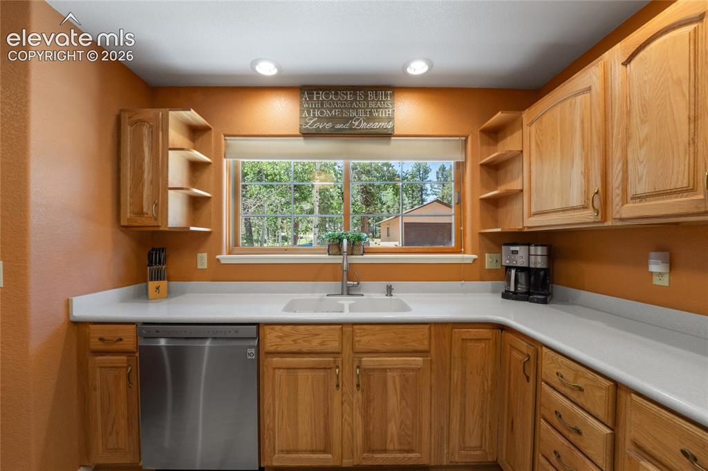 Image 19 of 43: U-shaped kitchen featuring light wood cabinetry, white countertops, and a s