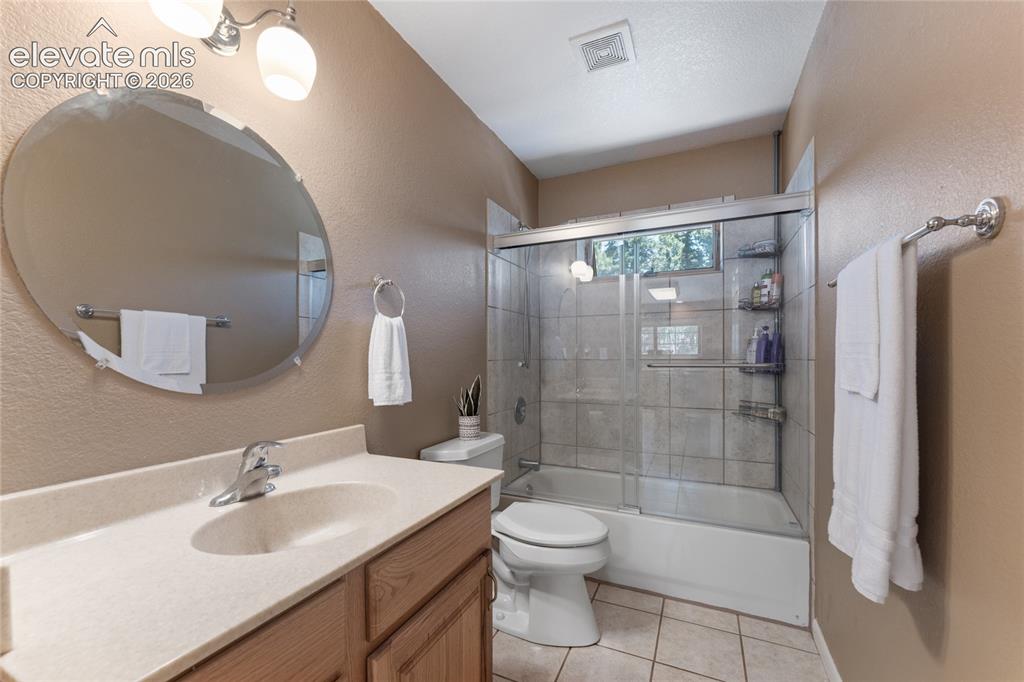 Image 21 of 43: Bathroom featuring a wood-finish vanity with a built-in sink, a large oval