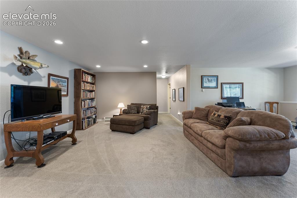 Image 25 of 43: Carpeted living space featuring recessed lighting and neutral wall tones