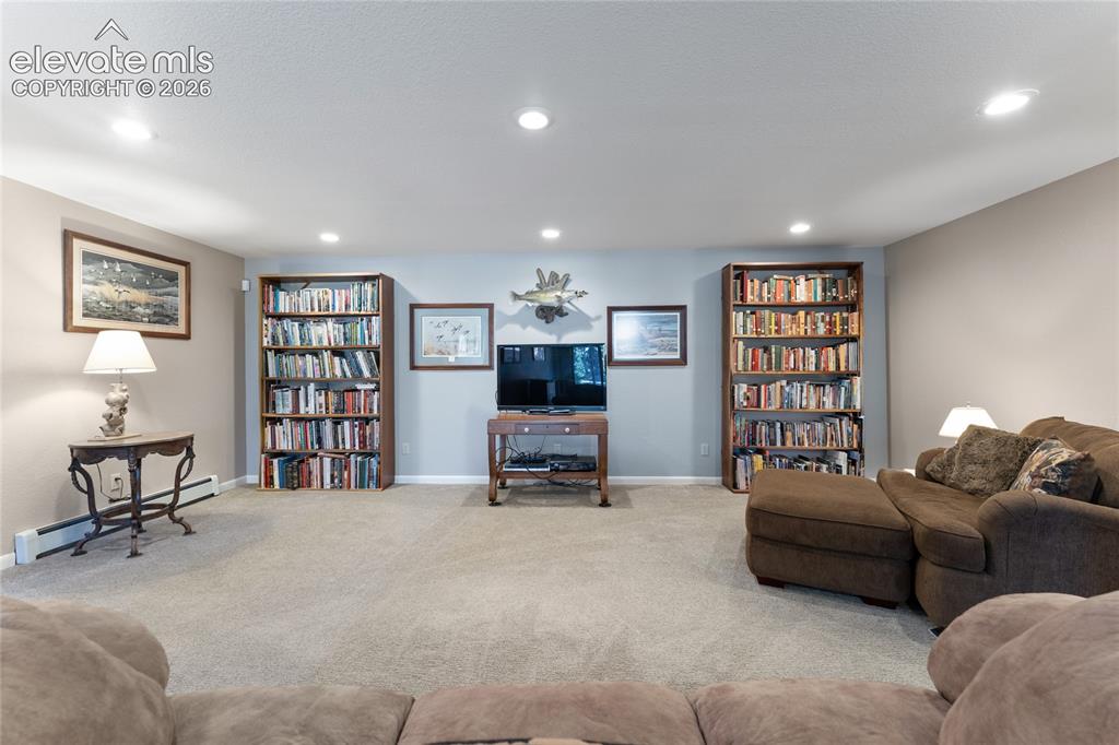 Image 29 of 43: Carpeted interior space featuring recessed lighting and built-in bookshelve