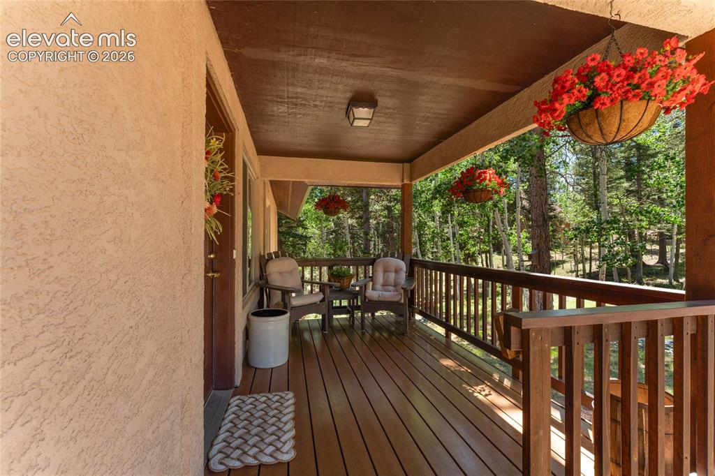 Image 3 of 43: Wood-finish deck with a wood railing system, visible treeline, and recessed