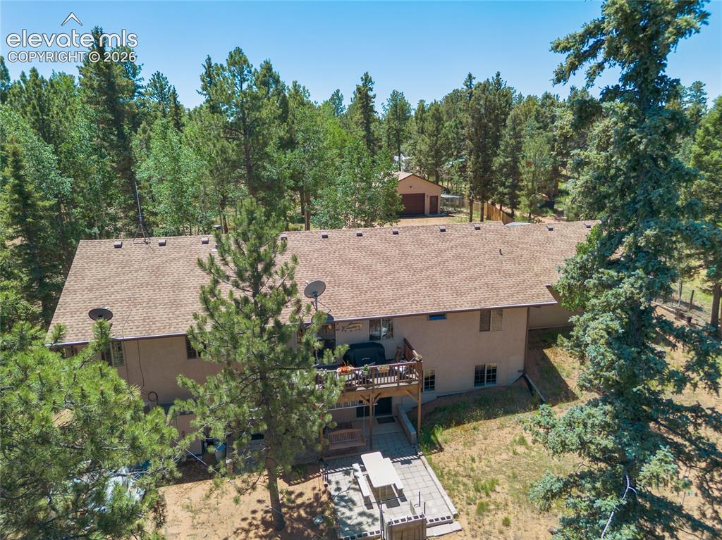 Image 42 of 43: Exterior featuring a multi-level structure with a brown shingle roof, a woo