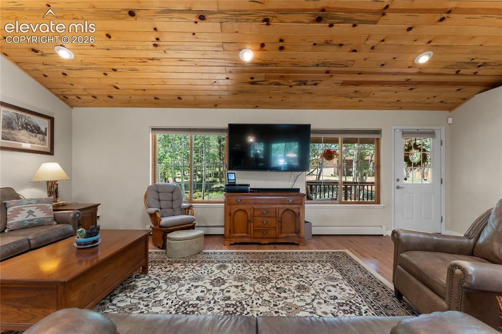 Image 6 of 43: Living area featuring a knotty pine ceiling with recessed lighting, wood-fi