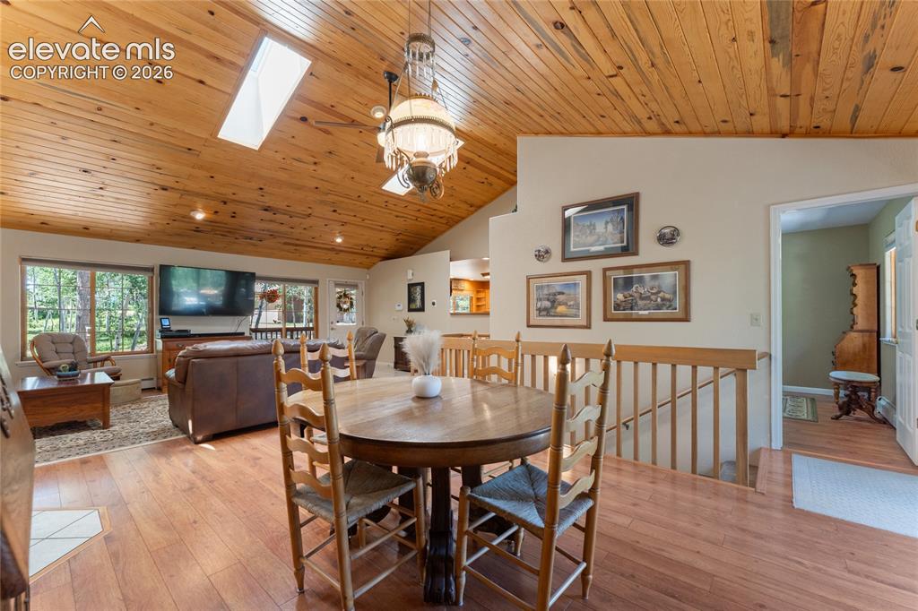 Image 9 of 43: Vaulted wood-paneled ceilings with skylights, wood-finish flooring, and a d