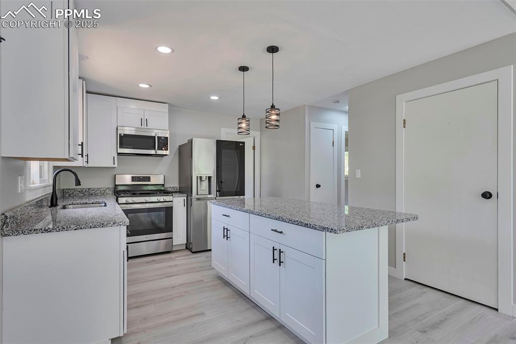 Image 11 of 33: Kitchen featuring white cabinets, appliances with stainless steel finishes,