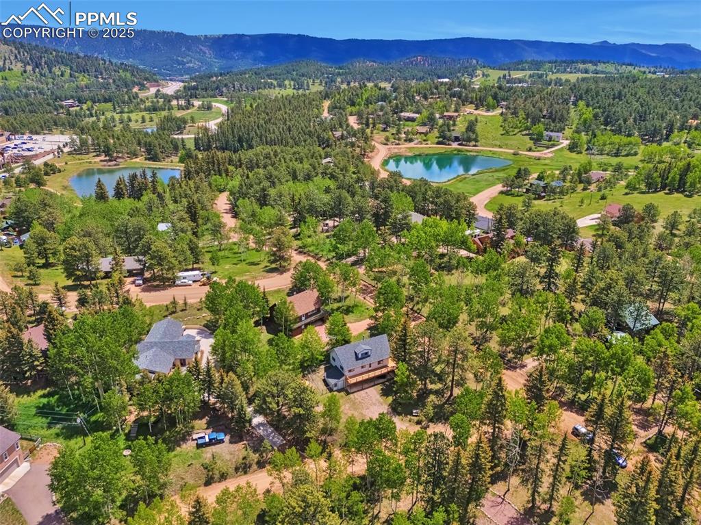 Image 2 of 33: Drone / aerial view of a water and mountain view and a heavily wooded area