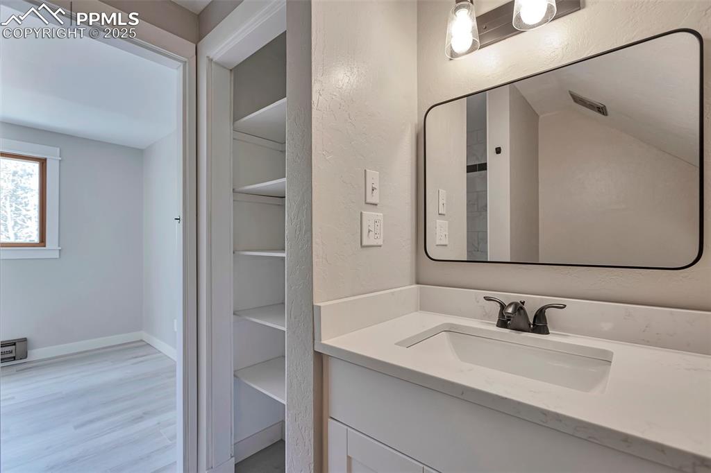 Image 20 of 33: Bathroom featuring vanity and linen closet.