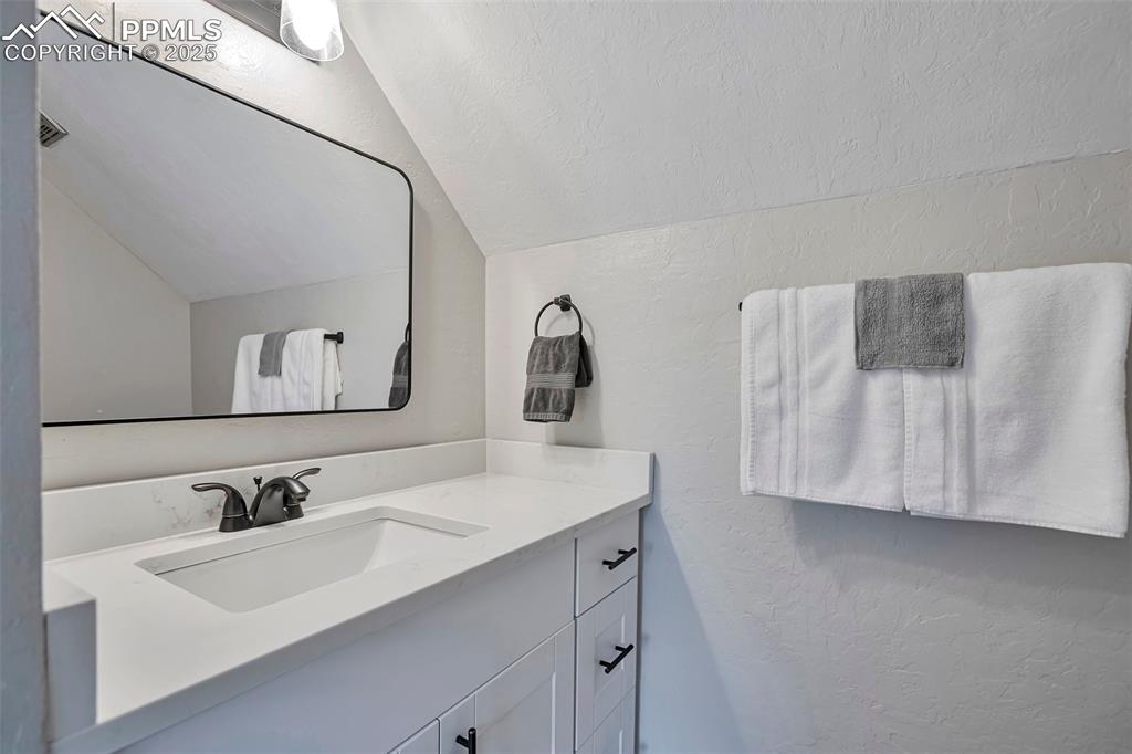 Image 21 of 33: Bathroom with white vanity.