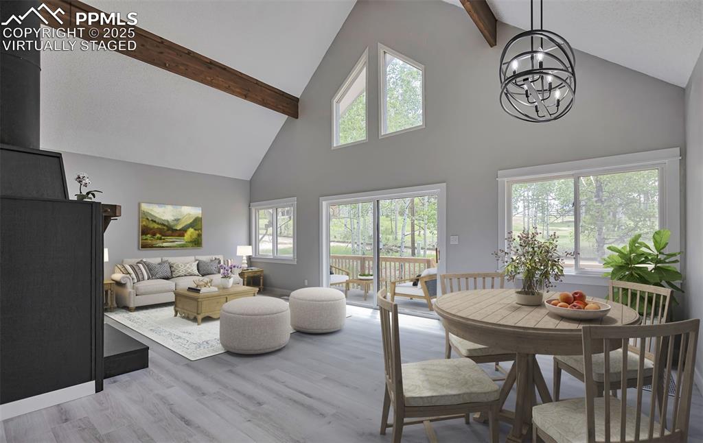 Image 4 of 33: Living Room/Dining area featuring high vaulted ceiling, beamed ceiling, lig