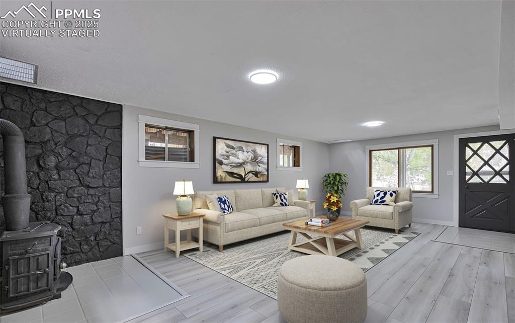 Image 6 of 33: Basement Living area with a wood stove and light wood-style flooring. Virtu