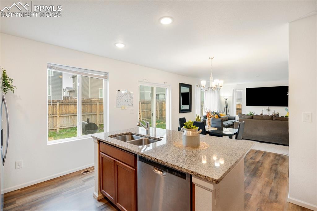 Image 11 of 29: Kitchen with stainless steel dishwasher, dark wood-style floors, a sink, a 