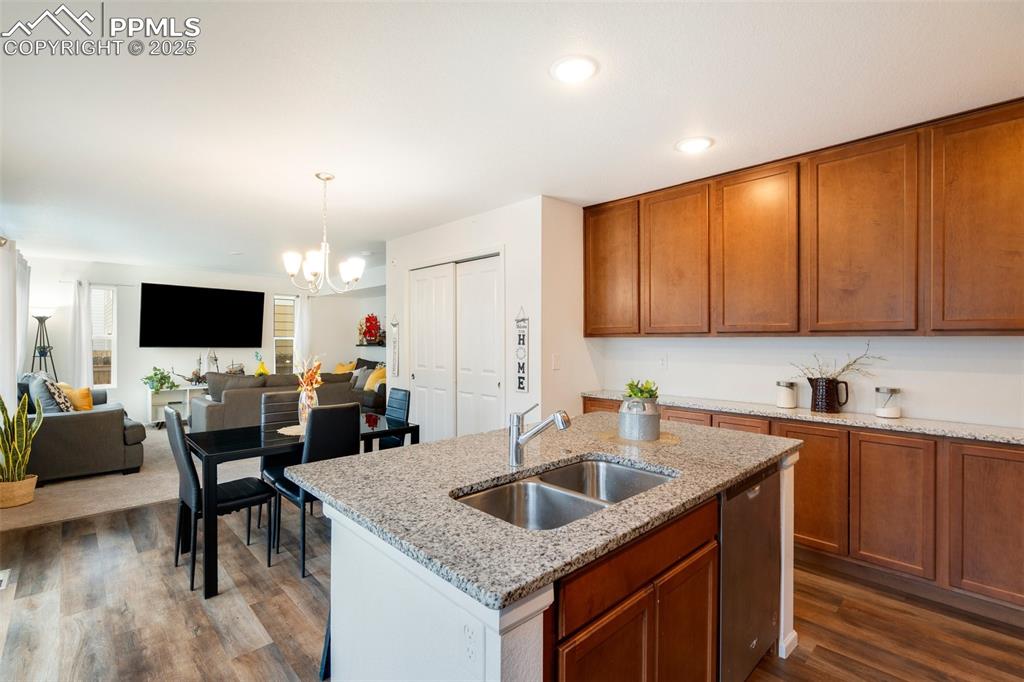 Image 13 of 29: Kitchen featuring a sink, dark wood-style flooring, a notable chandelier, b