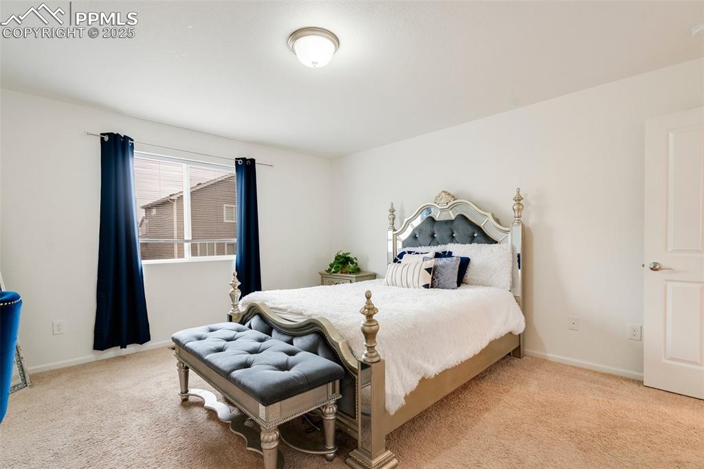 Image 20 of 29: Bedroom with baseboards and carpet floors