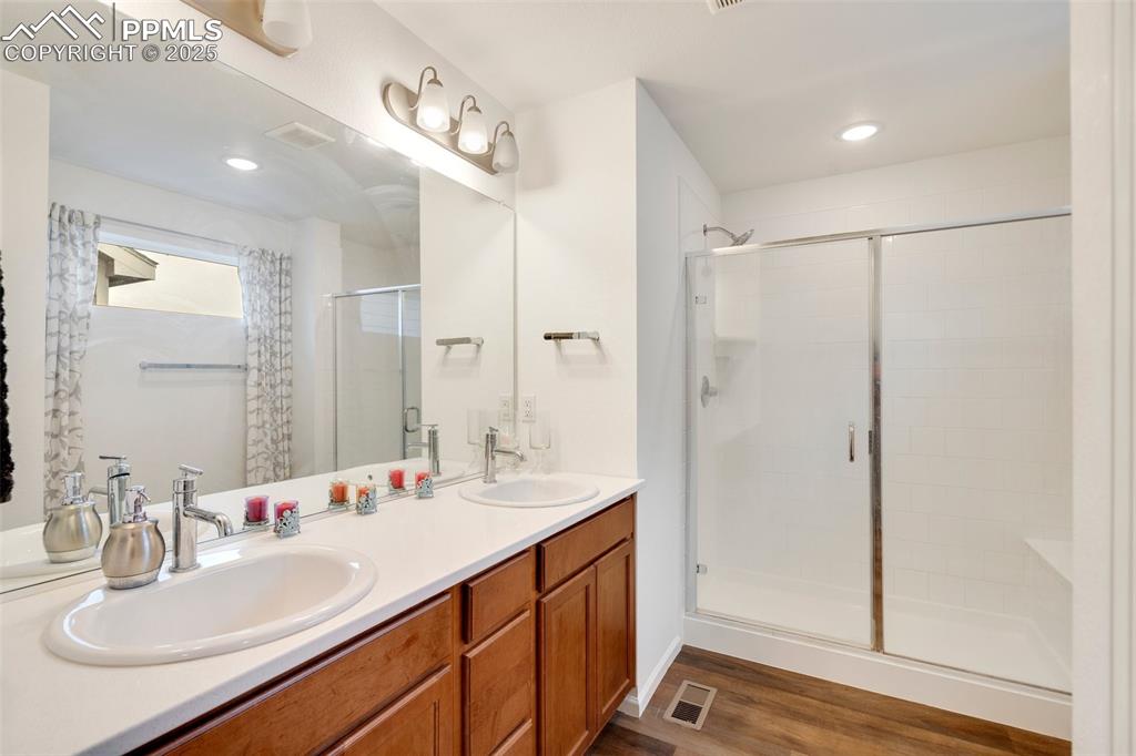 Image 21 of 29: Full bath featuring wood finished floors, a sink, visible vents, and a stal