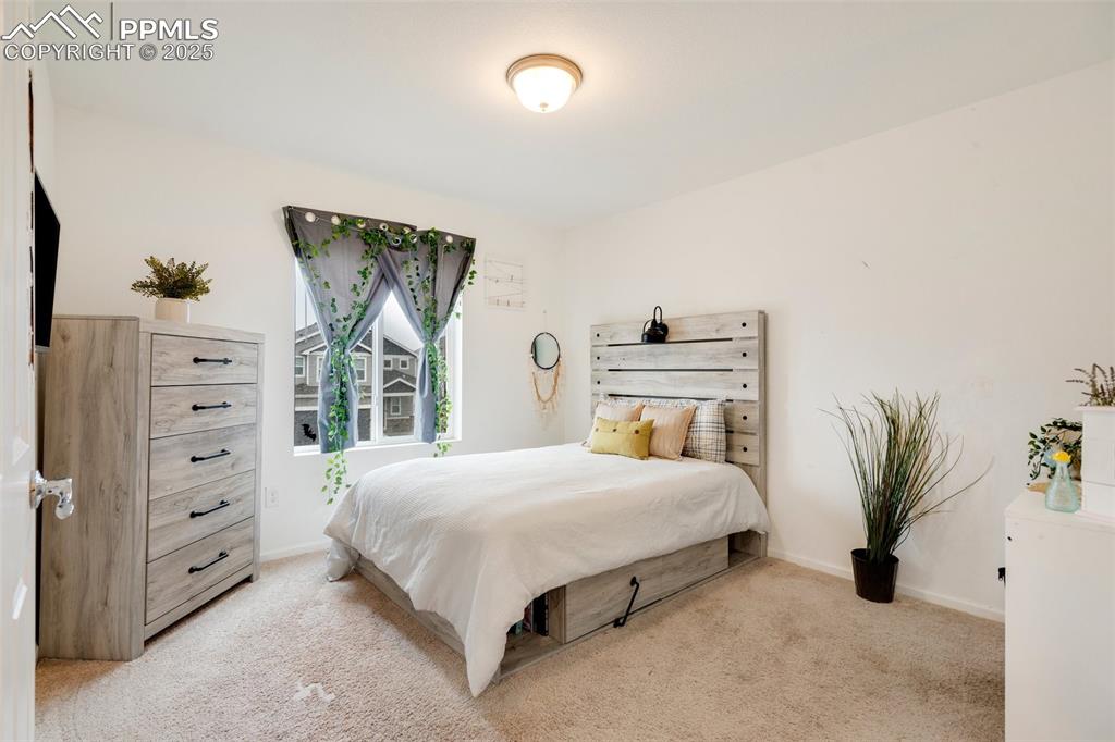 Image 24 of 29: Bedroom featuring light colored carpet and baseboards