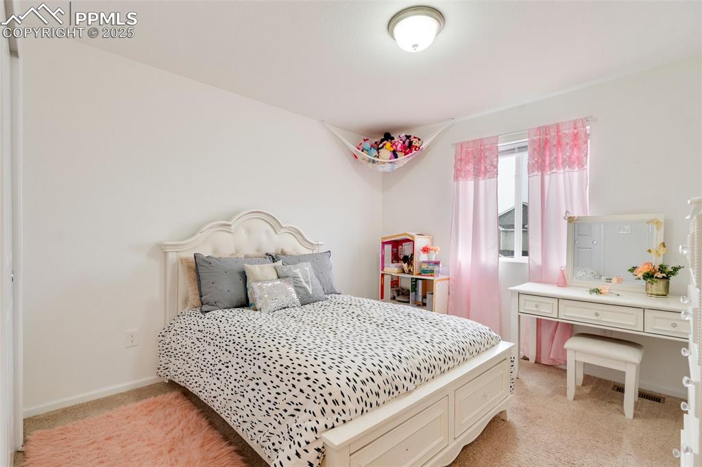 Image 27 of 29: Bedroom with baseboards, visible vents, and light colored carpet