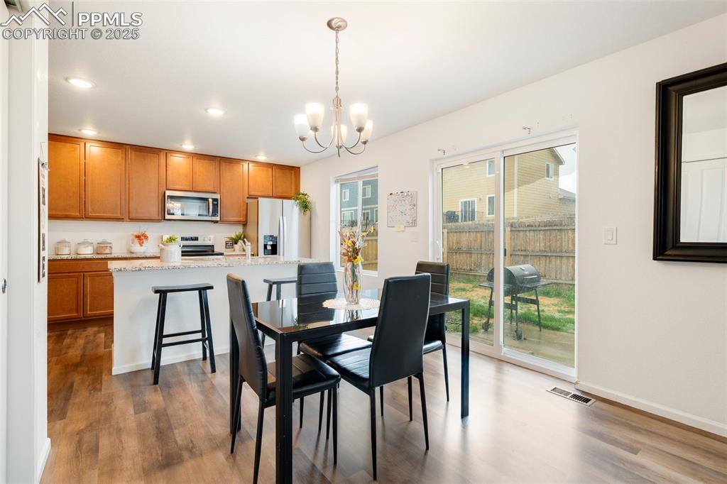Image 7 of 29: Dining space with recessed lighting, wood finished floors, visible vents, a