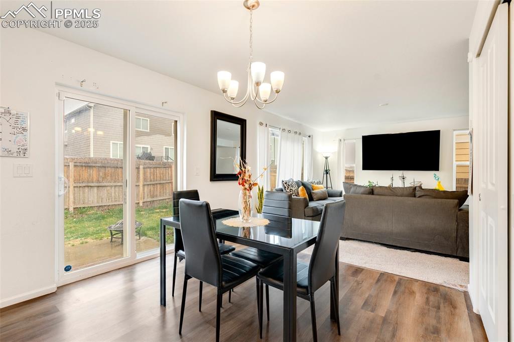 Image 8 of 29: Dining space featuring a chandelier, dark wood finished floors, and a healt