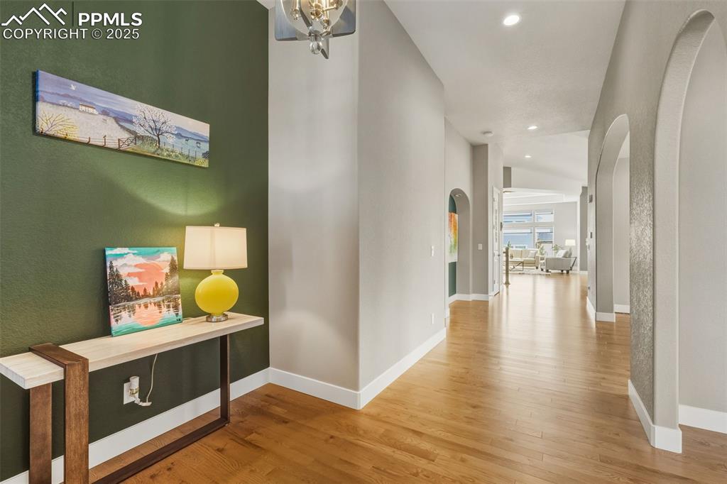 Image 12 of 49: Hall featuring light wood-style flooring, recessed lighting, and arched wal