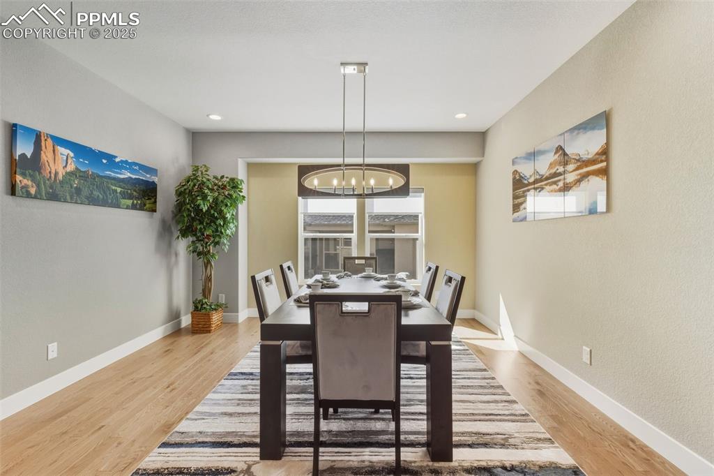 Image 19 of 49: Dining area with light wood-style flooring, a chandelier, recessed lighting