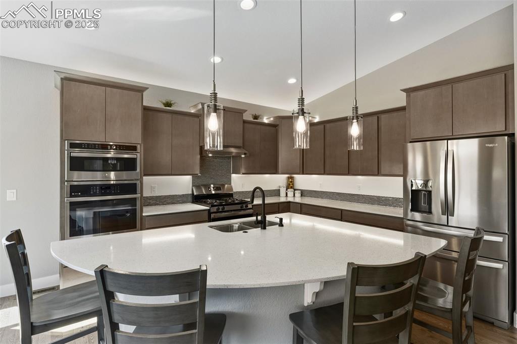 Image 23 of 49: Kitchen featuring stainless steel appliances, decorative light fixtures, a 