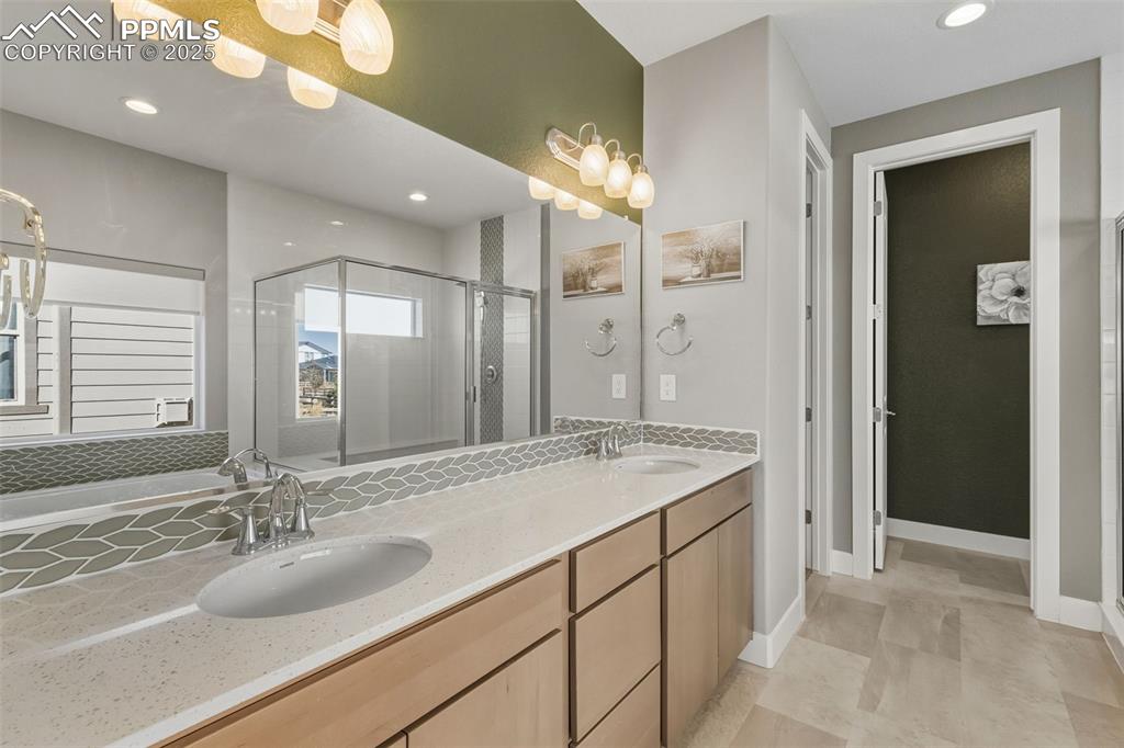 Image 31 of 49: Full bathroom featuring a shower stall, recessed lighting, double vanity, a
