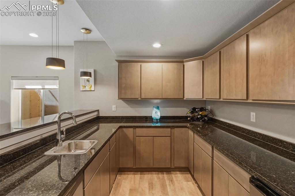 Image 40 of 49: Kitchen featuring decorative light fixtures, light wood finished floors, da